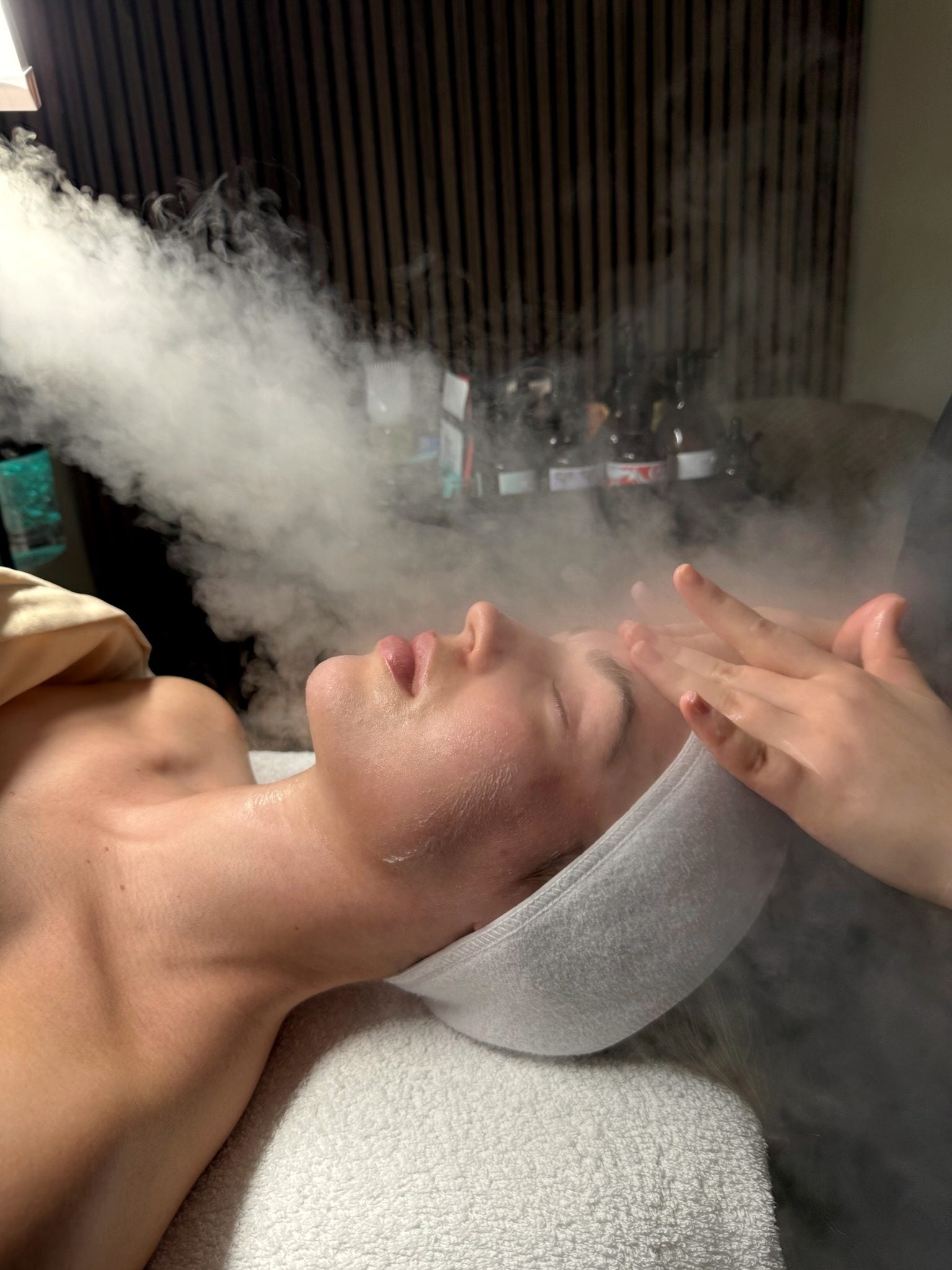 A client relaxing during a warm steam facial at REGEN Clinic — calm, doctor-led skin care for acne and texture.