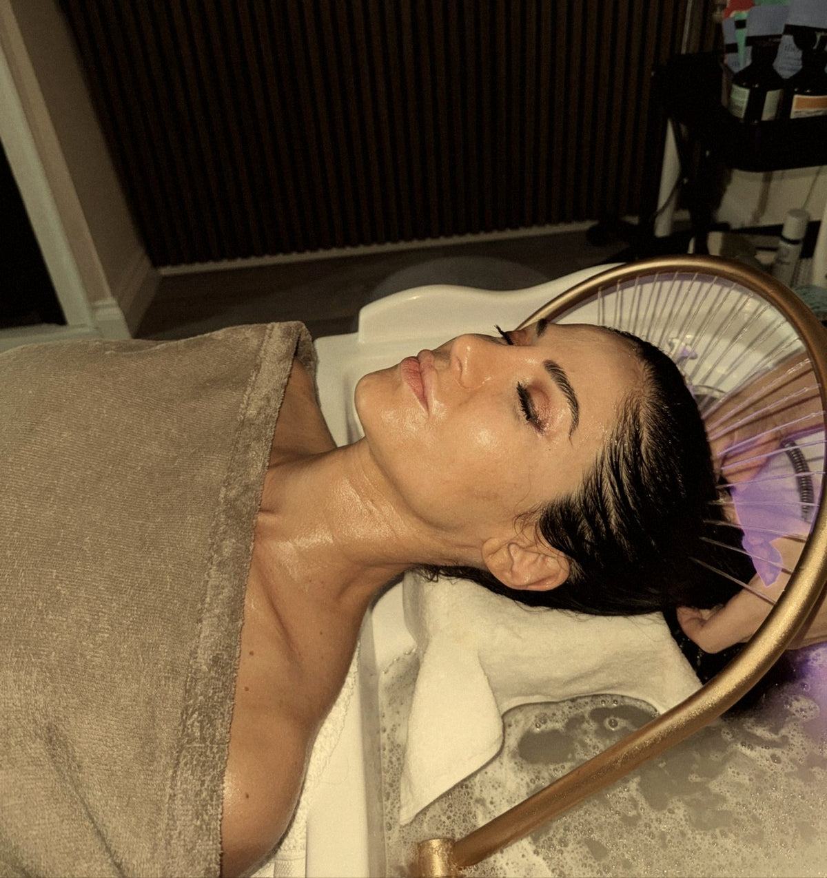 A client reclining during the REGEN Japanese Head Spa, the signature gold water-halo above her, Norwich.