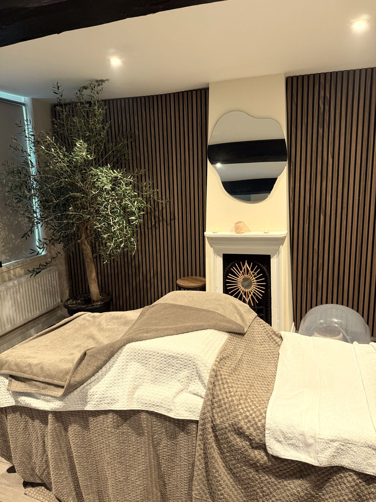 A REGEN Clinic Norwich Head Spa treatment room — warm wood, greenery and soft light.