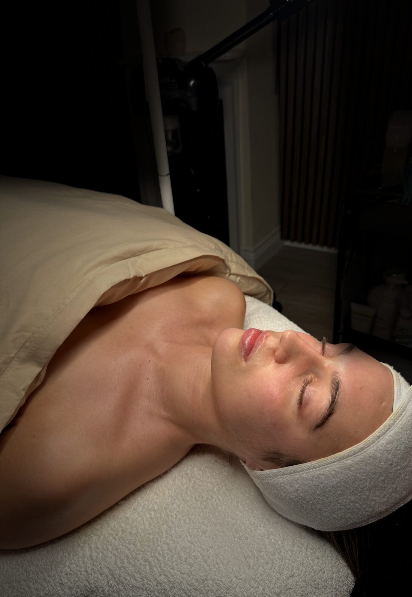A client resting during a REGEN Clinic facial - calm, luminous skin in soft warm light ahead of an event.